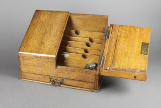 An Edwardian honey oak wedge shaped stationery box with  hinged lid, the base fitted a drawer 15"w x 11"h x 8"d