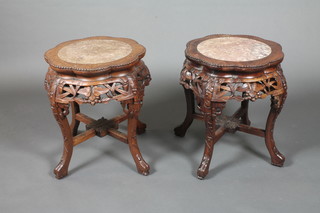 A pair of circular Chinese carved hardwood jardiniere stands with pink veined marble tops 16" diam. x 19"h