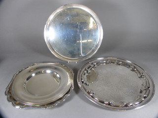 A circular silver plated salver raised on 3 bracket feet 12" and 4 other salvers