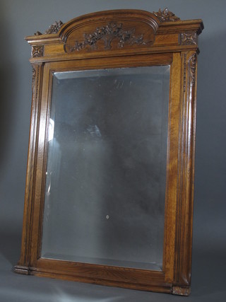 A Continental rectangular bevelled plate wall mirror contained in  an arched carved oak frame 49" x 34"
