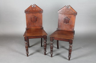 A pair of Victorian carved mahogany hall chairs with solid seats