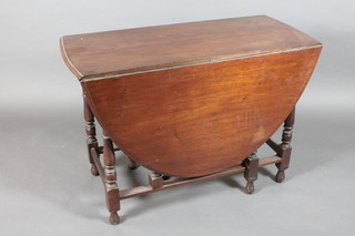 A 19th Century mahogany oval drop flap gateleg dining table  raised on turned supports 42"w x 28" 1/2"h 59"d