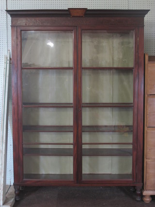 A Victorian mahogany bookcase with moulded cornice, fitted adjustable shelves enclosed by glazed panelled doors, raised on  turned supports 50"w x 69"h x 14"d