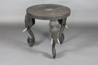 An Indian ebonised circular carved table with ivory tusks 24 1/2" x 25"