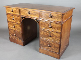 A Victorian mahogany kneehole pedestal desk with inset writing surface above 1 long and 8 short drawers, raised on a platform  base 48"w x 31"h x 21 1/2"d
