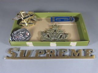 A Cortina car badge, a Supreme badge, a belt buckle, a Welsh  plaque and 1 other badge