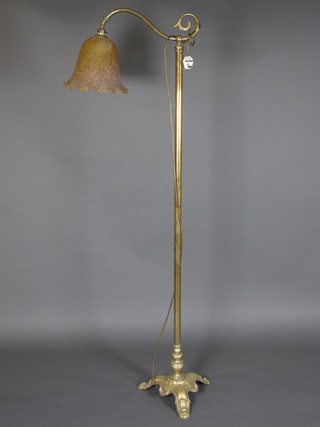 An Art Nouveau brass standard lamp with glass shade