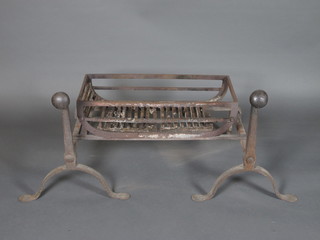 A pair of iron fire dogs and a fire basket