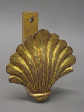 A carved wooden and gilt painted curtain tie back in the form of  a shell