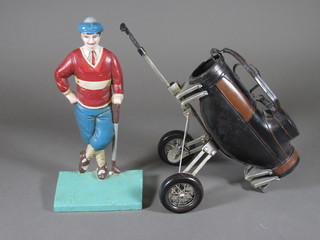 An iron door stop in the form of a standing golfer 10" and a  model of a golf trolley 10"
