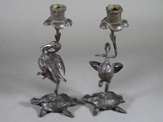 A pair of bronze candlesticks in the form of standing birds on turtles 9 1/2", 1 beak f,