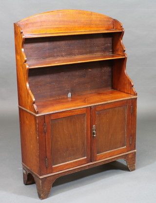 A 19th Century mahogany waterfall bookcase with arch shaped  top, the base fitted a cupboard enclosed by panelled doors, raised  on bracket feet 30"w x 44 1/2"h x 10"d
