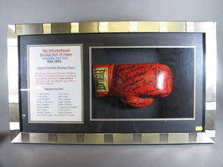 A red signed Everlast boxing glove, formerly part of the  collection of John Redfern signed by Leon Spinks, Carmen Basilio, Tony De Marco, Sandy Saddler, 14 other ex boxers and  John Amos - star of Roots, framed and glazed