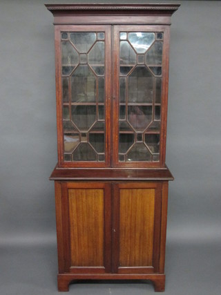 A 19th Century mahogany bookcase on cabinet with moulded and  dentil cornice, fitted adjustable shelves enclosed by astragal  glazed doors, the base fitted a cupboard enclosed by a pair of  panelled doors, raised on bracket feet 36"w x 82 1/2"h x 17  1/2"d