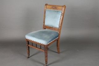 A late Victorian carved standard chair with upholstered seat and back, raised on turned supports