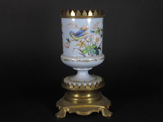 A Victorian opaque glass oil lamp decorated birds, raised on a pierced brass foot