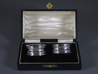 A pair of waisted silver napkin rings, Chester 1913 and 1914,  cased