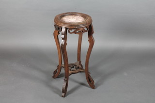 An Eastern circular pierced and carved hardwood jardiniere stand, the top inlaid a red marble panel, raised on cabriole  supports