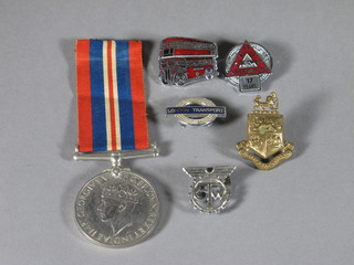 A WWII British War medal, a London transport enamelled badge, a double decker bus enamelled badge, a TWG badge, 1  other enamelled badge and a brass collar dog