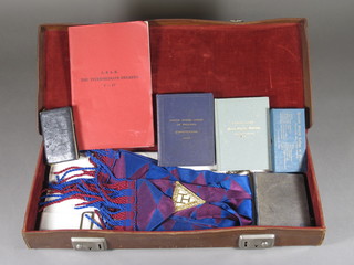 An attache case containing a Masonic Royal Arch Companions apron and sash and various books