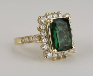 A 14ct yellow gold dress ring set a rectangular green tourmaline  approx 6ct, surrounded by diamonds approx 1.10ct