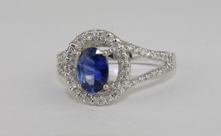 A lady's 18ct white gold dress ring set an oval cut sapphire  surrounded by diamonds