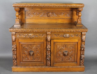 A Victorian carved honey oak sideboard with raised back, the  base fitted 2 drawers above a double cupboard 62"w x 55 1/2" x  23"