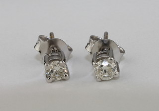 A pair of lady's diamond stud earrings set in a claw mount,  approx 0.36ct