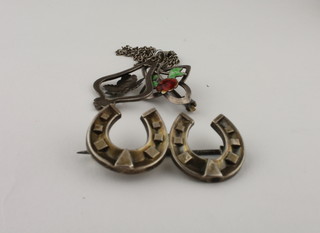 A silver horse shoe brooch, a silver chain hung an enamelled pendant and a silver and enamelled brooch