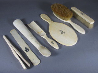 An ivory backed hand mirror, a clothes brush, hair brush, 2 shoe horns, pair of glove stretchers and a letter opener