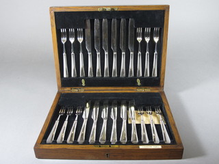 A set of 12 silver plated fruit knives and forks contained in an oak canteen box