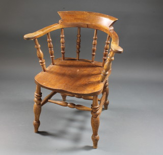An elm Captain's chair with H framed stretcher, raised on turned supports