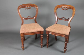 A pair of Victorian mahogany balloon back bedroom chairs with carved mid rails and upholstered drop in seats, on turned supports
