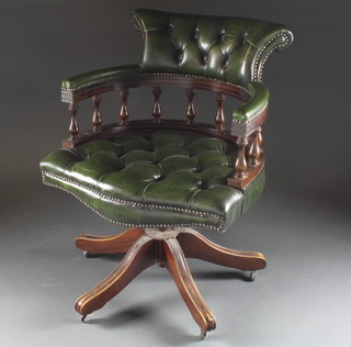 A Georgian style mahogany framed revolving office chair upholstered in green leather