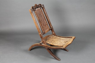 A Victorian pierced and carved mahogany folding chair with  woven cane seat and back
