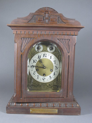 An Edwardian chiming mantel clock with 6 1/2" gilt dial,  silvered chapter ring and Arabic numerals, contained in an oak  case