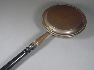 A Victorian copper warming pan with turned ebony handle