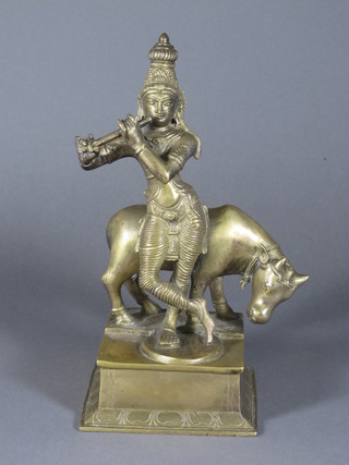 A heavy gilt metal figure of an Eastern Deity and Cow 11"