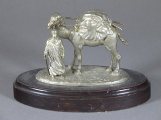 A white metal figure of a standing Nomad and camel raised on an  oval base 26"