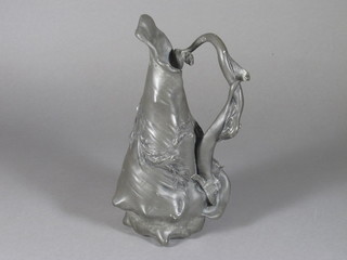 A French Art Nouveau pewter jug in the form of a seashell the handle in the form of a dolphin, the base marked Etain Carant  Pur Paris 10"