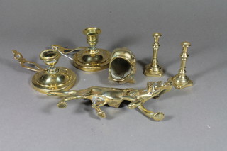 A pair of brass chamber sticks, a brass figure of a dog, a pair of miniature brass candlesticks and a figure of a fish