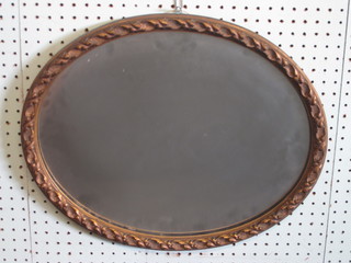 An oval bevelled plate wall mirror contained in a gilt frame 19"