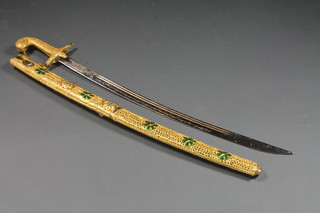 An Arabian mameluke style sword contained in a decorative gilt scabbard