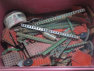 A crate containing a collection of various green and red Meccano
