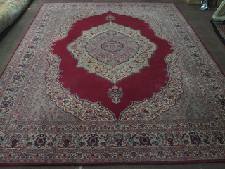 A machine made red ground Persian style carpet with central medallion 145" x 109"