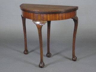 A Georgian style demi-lune card table raised on cabriole ball and  claw supports 30"w x 28"h x 15"d