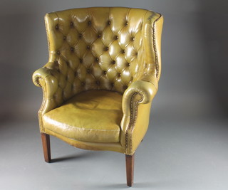 A Georgian style tub back chair upholstered in green buttoned  back leather raised on square tapering supports