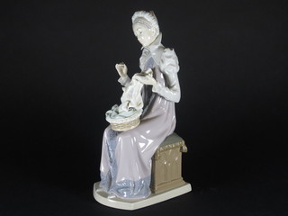A Lladro figure of a seated lady sewing 11"