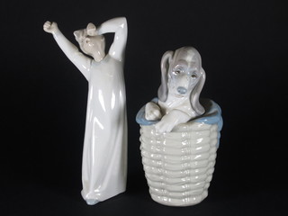 A Lladro figure of a puppy emerging from a basket 7" and 1  other of a standing yawning boy 8"