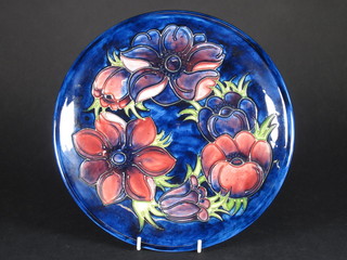 A circular Moorcroft blue glazed charger decorated Anemones,  the base impressed Moorcroft 10"  ILLUSTRATED